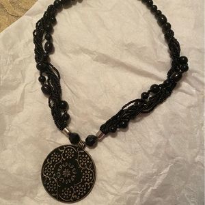 Black necklace with black and gold pendant.